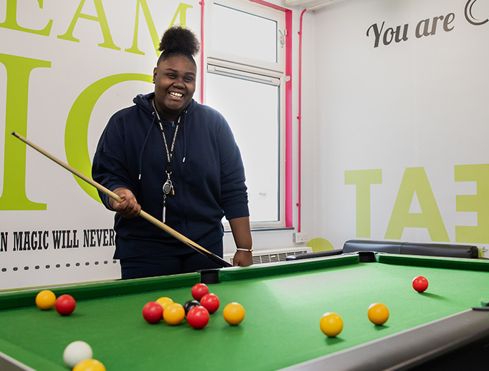 Students playing pool in the common room