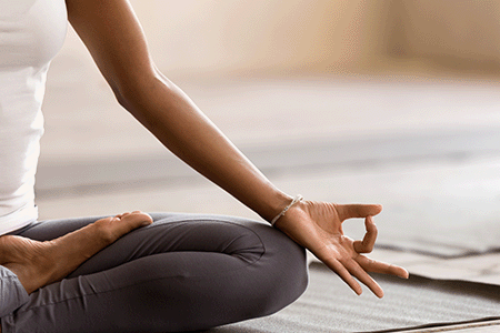 A knee and hand of someone in a yoga pose